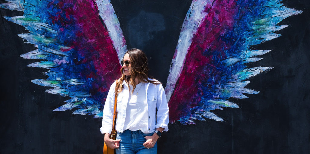 Influencer in front of wing wall painting