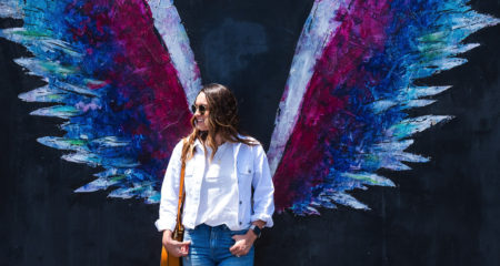 Influencer in front of wing wall painting