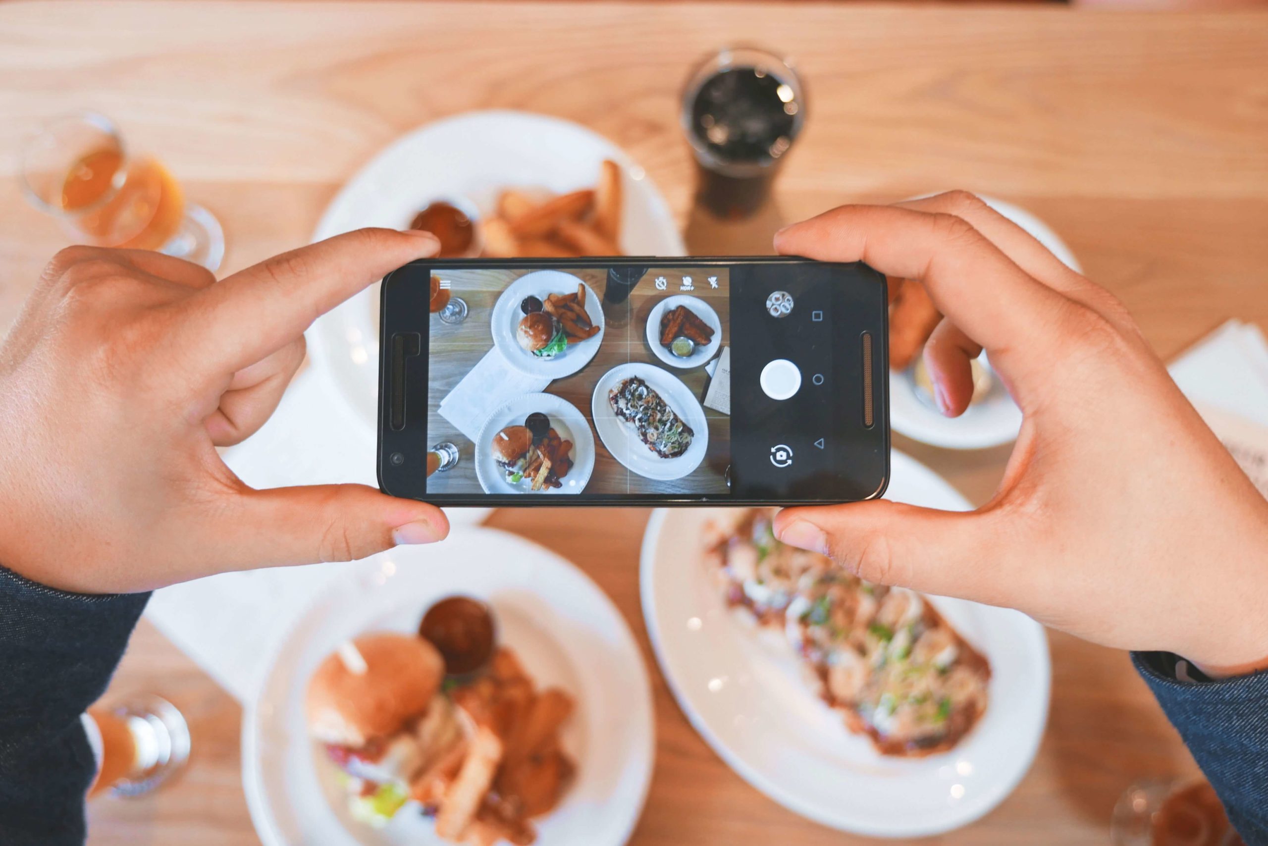 person taking a photograph of food for social media